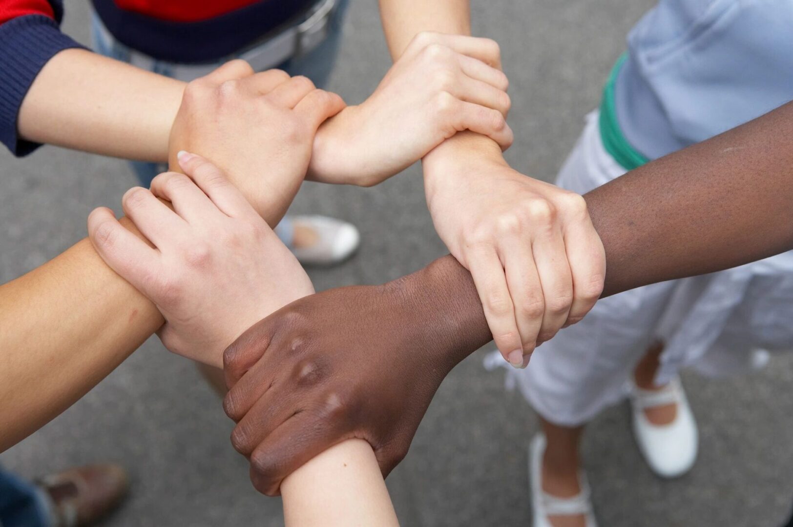 A group of people holding hands in the middle of a circle.